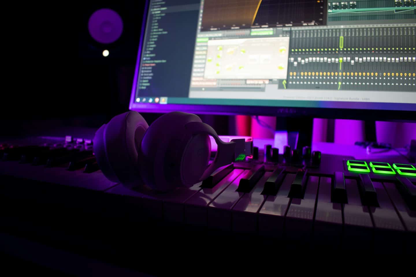 Headphones on a MIDI keyboard controller in a music studio.